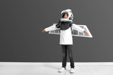 Genç bir çocuk pilot kaskıyla uçtuğunu hayal ediyor.