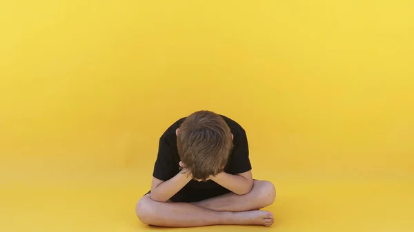 情绪低落的孩子坐在彩色地板上 — 图库照片