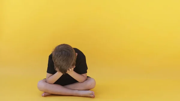 情绪低落的孩子坐在彩色地板上 — 图库照片