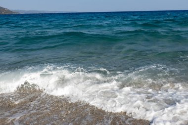 Sahildeki mavi denizde beyaz dalgalar