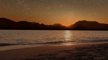 Gece denizi, dağların manzarası ve yıldızlı gökyüzü