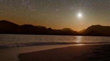 Yıldızlar gece gökyüzünde parıldıyor Noel tatilinde denizin üzerinde