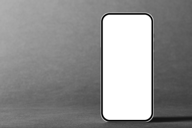 Gri arka planda, okula dönüş ilanı için cep telefonu.