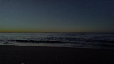 Gece gökyüzünde dağların manzaralı bir yıldız hareketi..