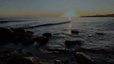 Gece gökyüzünde dağların manzaralı bir yıldız hareketi..