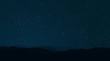 Gece gökyüzünde dağların manzaralı bir yıldız hareketi..
