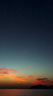 Yumuşak dalgalar ve sönen yıldızlarla huzurlu, rüya gibi bir atmosferde gün doğumu