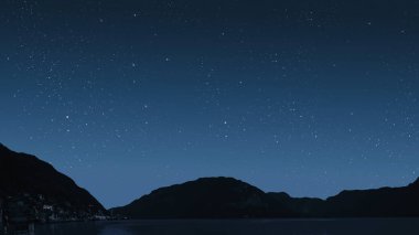 Gece gökyüzünde dağların manzaralı bir yıldız hareketi..