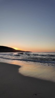 Sahilde gün doğumu sakin ve dalgalı