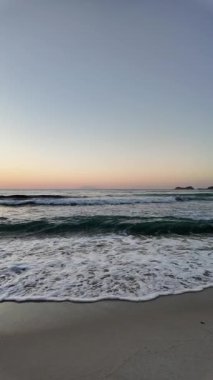 Sahilde gün doğumu sakin ve dalgalı