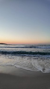 Sahilde gün doğumu sakin ve dalgalı