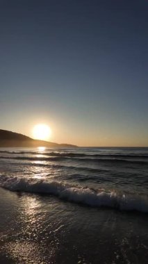 Sahilde gündoğumu sakin ve dalgalı. 