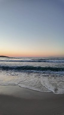 Sahilde gündoğumu sakin ve dalgalı. 