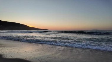 Sahilde gündoğumu sakin ve dalgalı. 