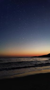 Dağları ve aydınlık evleri olan huzurlu bir kasabanın üzerinde gece gökyüzünde parlayan parlak bir Noel yıldızı..