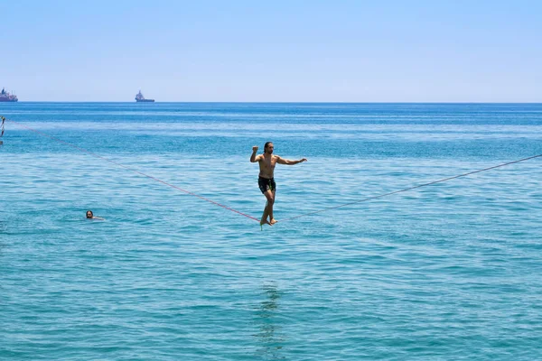 キプロスのLimassol 2021年7月9日 海の上のロープを歩いている未確認の若者 海で泳いでいる他の1人 — ストック写真