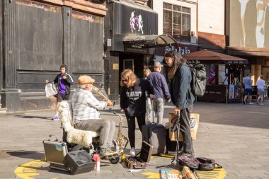 Londra, Birleşik Krallık - 24 Eylül 2021 - Sokak müzisyeni Guy Stuart Leicester Meydanı 'ndaki insanlara saksafonunu gösteriyor.