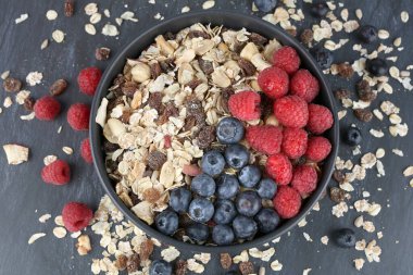 Siyah fonda ahududu ve yaban mersinli Muesly..