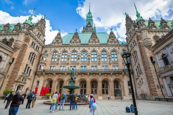 stock image Hamburg, Germany - July 14, 2024 - Hygieia fountain in the inner courtyard of Hamburg City Hall (Hamburger Rathaus), seat of local government of the Free and Hanseatic City of Hamburg. Tourists at the Hygieia bronze statue.