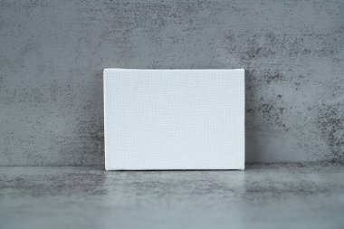 Gri duvardaki boş dikdörtgen tuval.