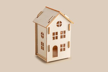 Ahşap ev modeli bej arka planda izole edildi.