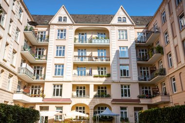 Balkonları bitki ve çiçeklerle dolu bir bina. Duvarlarda inanılmaz süslemeler var..