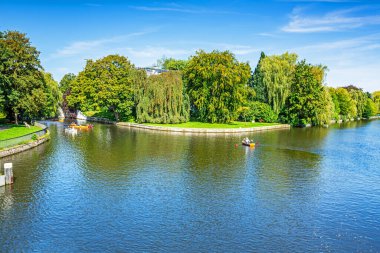 Alster Nehri, Almanya 'nın Hamburg kentinde bulunan Elbe Nehri ve Eichenpark' ın sağ koludur. Güneşli bir günde nehrin kenarındaki parkta dinlenen insanlar..