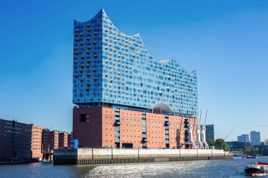 Hamburg, Almanya 'daki sembolik Elbphilharmonie konser salonunun parlak cam cephesi. Modern, dalga biçimli Elbe nehrinden bina manzarası.