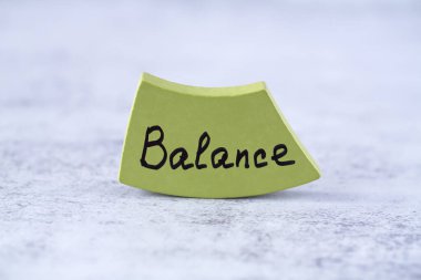 Gri arka plandaki yeşil tahta üzerinde denge kelimesi. Hayatta başarı için motivasyon kelimeleri.