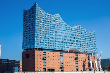 Hamburg, Almanya 'daki sembolik Elbphilharmonie konser salonunun parlak cam cephesi. Modern, dalga biçimli Elbe nehrinden bina manzarası.