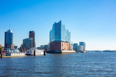 Hamburg, Almanya 'daki sembolik Elbphilharmonie konser salonunun parlak cam cephesi. Modern, dalga biçimli Elbe nehrinden bina manzarası.