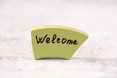 Gri arka plandaki yeşil tahta tahtaya hoş geldiniz. Davet ve yenilikler için motivasyon kelimesi.