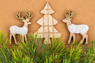 Kahverengi kağıttan arka planda geyik ve köknar ağacı oyuncakları. Noel oyuncakları dekorasyonu.
