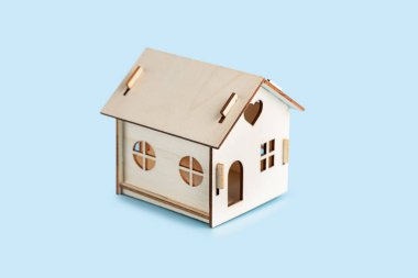 Ahşap ev modeli mavi arka planda izole edildi.