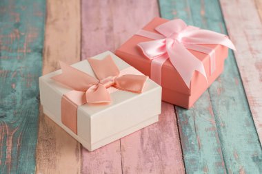 Renkli ahşap arka planda kurdeleli iki hediye kutusu..