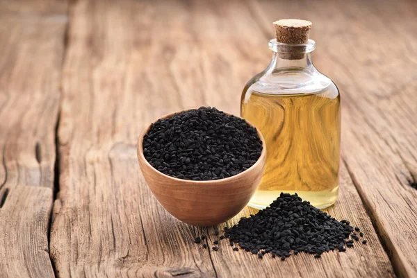 Schwarzkümmelöl Mit Samen Auf Holzbrett — Stockfoto