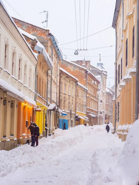 乌克兰利沃夫 冰雪覆盖的利沃夫老城街道 有咖啡馆和餐馆 汽车在巨大的雪堆中 — 图库照片