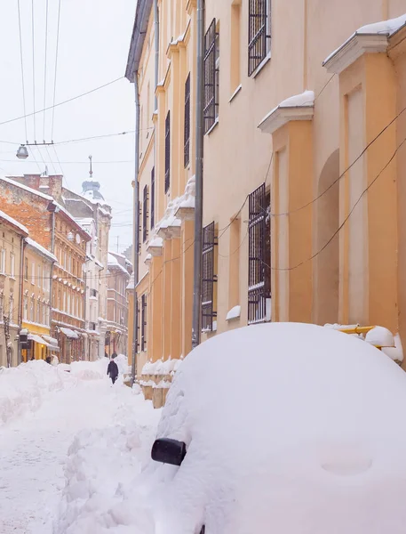 乌克兰利沃夫 冰雪覆盖的利沃夫老城街道 有咖啡馆和餐馆 汽车在巨大的雪堆中 — 图库照片