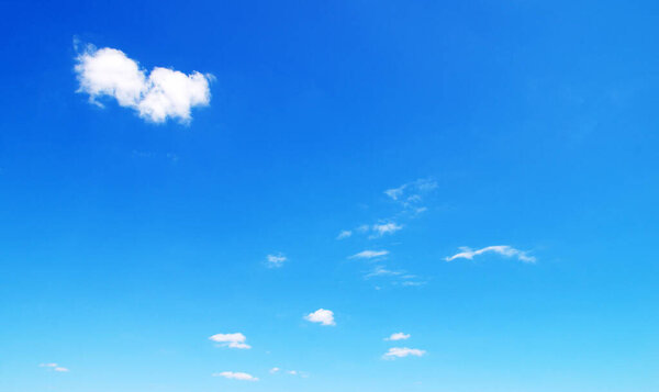 white fluffy clouds with rainbow in the blue sky