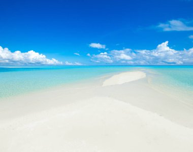 Güzel sahil. Tropik plaj. Tatil ve tatil konsepti. Kum, mavi deniz suyu, turkuaz okyanus, güneş gökyüzü beyaz bulutlar.