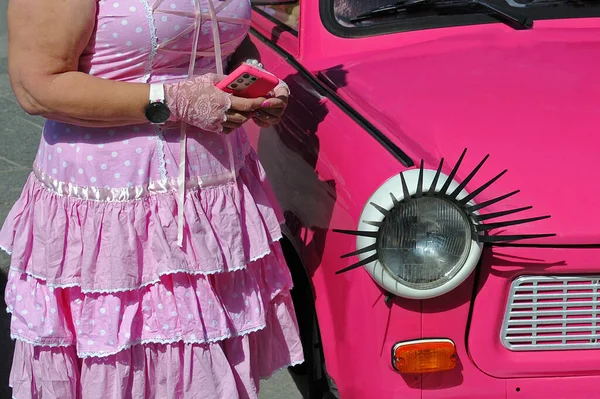 분홍색 핸드폰을 여성의 일부와 속눈썹으로 장식된 머리등 분홍색으로 앞부분의 사진을 — 스톡 사진