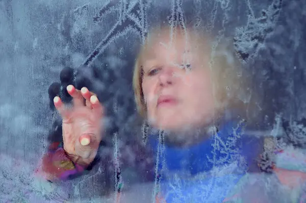 stock image Fuzzy portrait of Caucasian woman through the frosty window in the winter