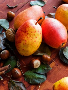Yemek reklamı konsepti. Armutlar ahşap masada. Tahta arka planda duran taze armutlar ve fındıklar. Üst görünüm.