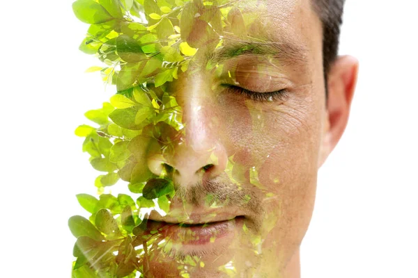 緑の葉と組み合わせた二重露光技術で目を閉じた男の肖像画 — ストック写真