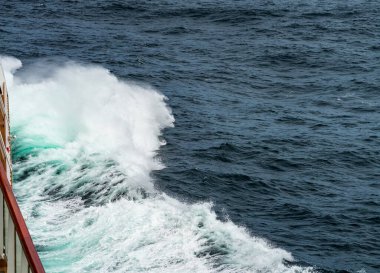Bow of cruise ship in heavy seas and swell with waves crashing from the front of boat