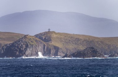 Monument on cliffs by Cape Horn depicts albatross in flight clipart