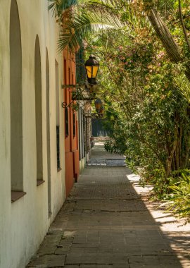 Unesco şehri Colonia del Sacramento Uruguay 'daki gölgeli sokağın taş duvarındaki sokak lambası ya da feneri.