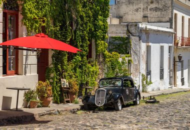 Colonia del Sacramento, Uruguay - 5 Şubat 2023: Kombine caddesindeki yerel bar veya kafe yakınlarında eski bir antika araba
