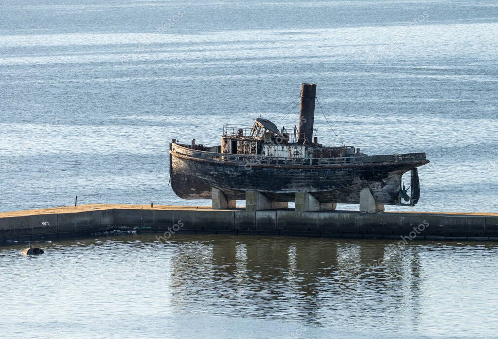 Buque de vapor de madera abandonado en gradas en muelle en el puerto de