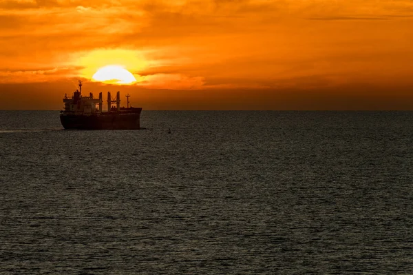 Naplemente Vízhorizonton Egy Ömlesztettáru Szállító Teherhajó Elhajózásával — Stock Fotó